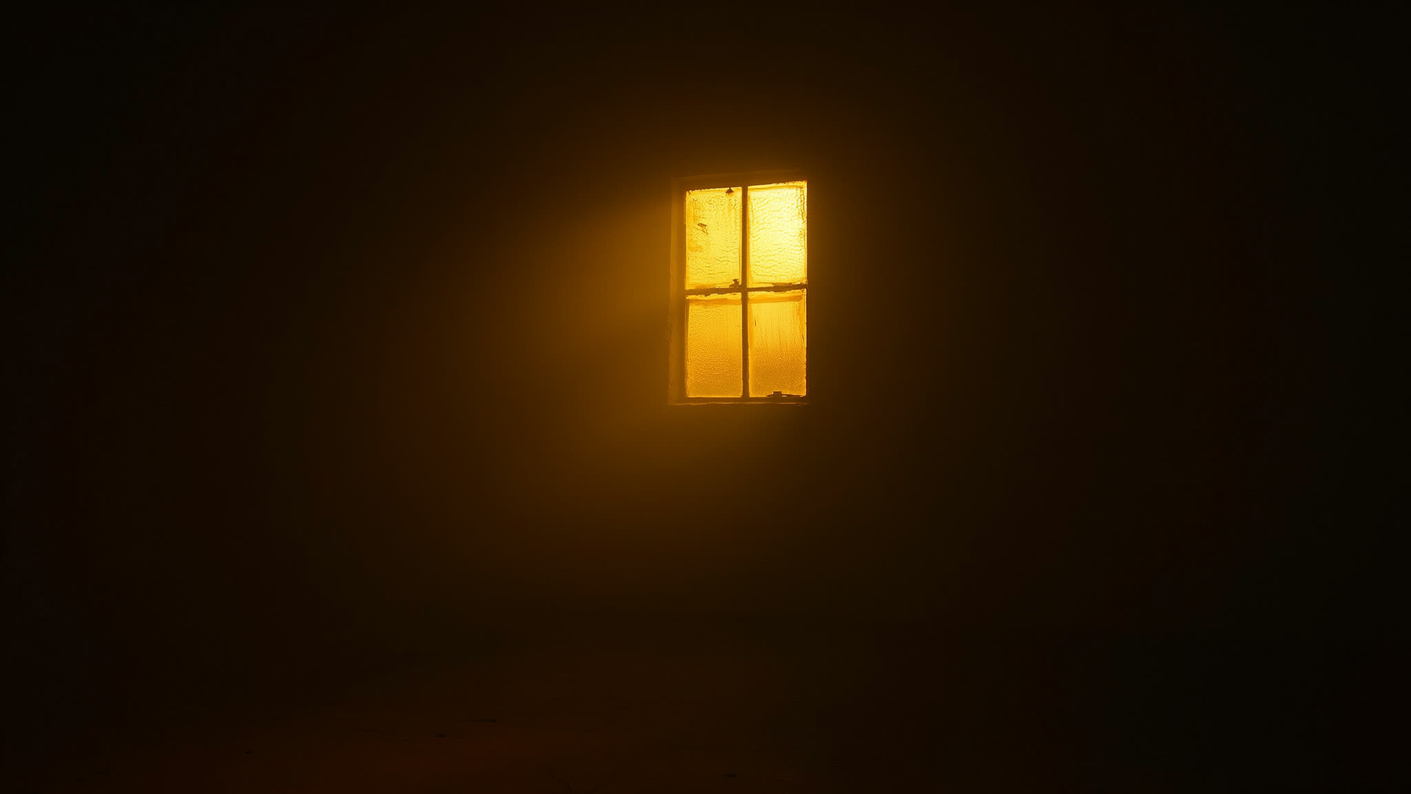 A window fogged from the inside with one small clear patch letting warm light through.